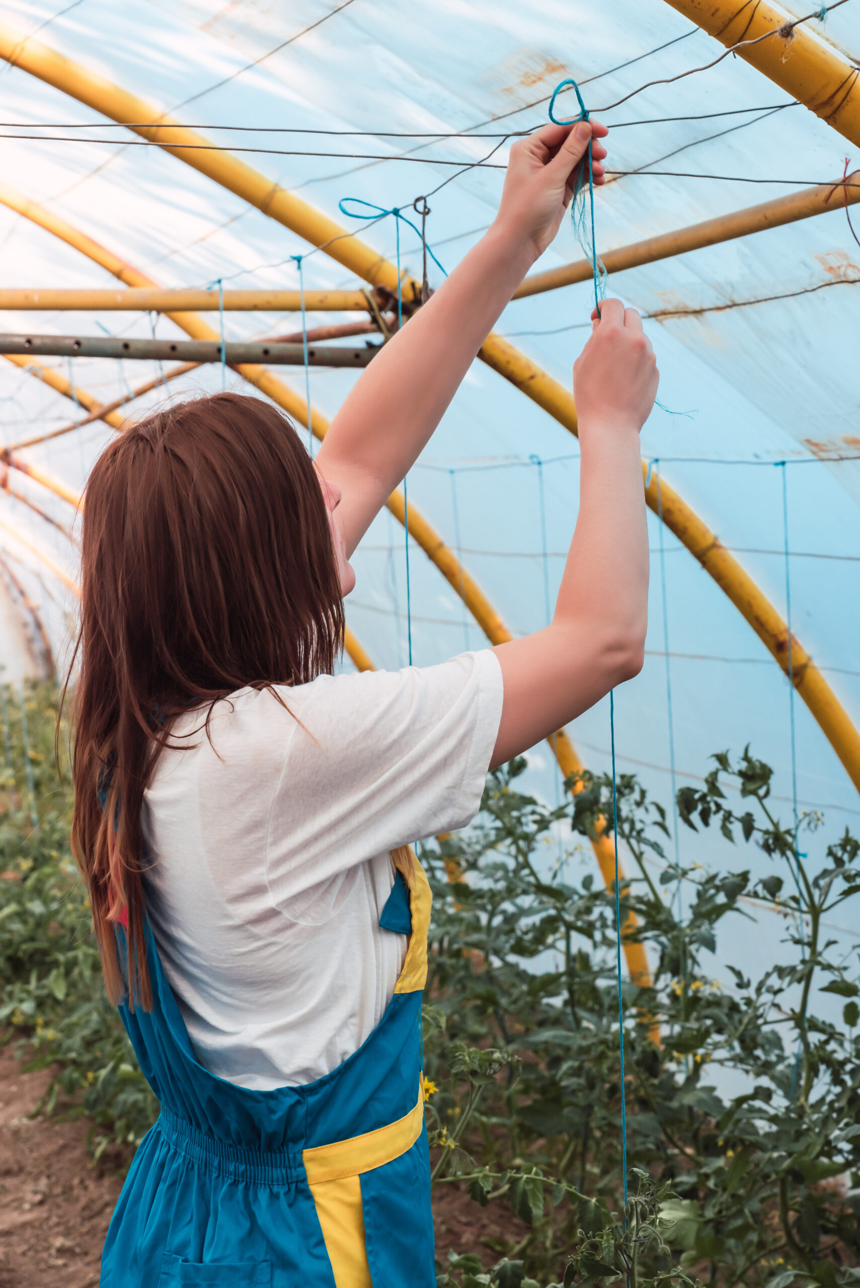 A closeup shot of a young female in a greenhouse