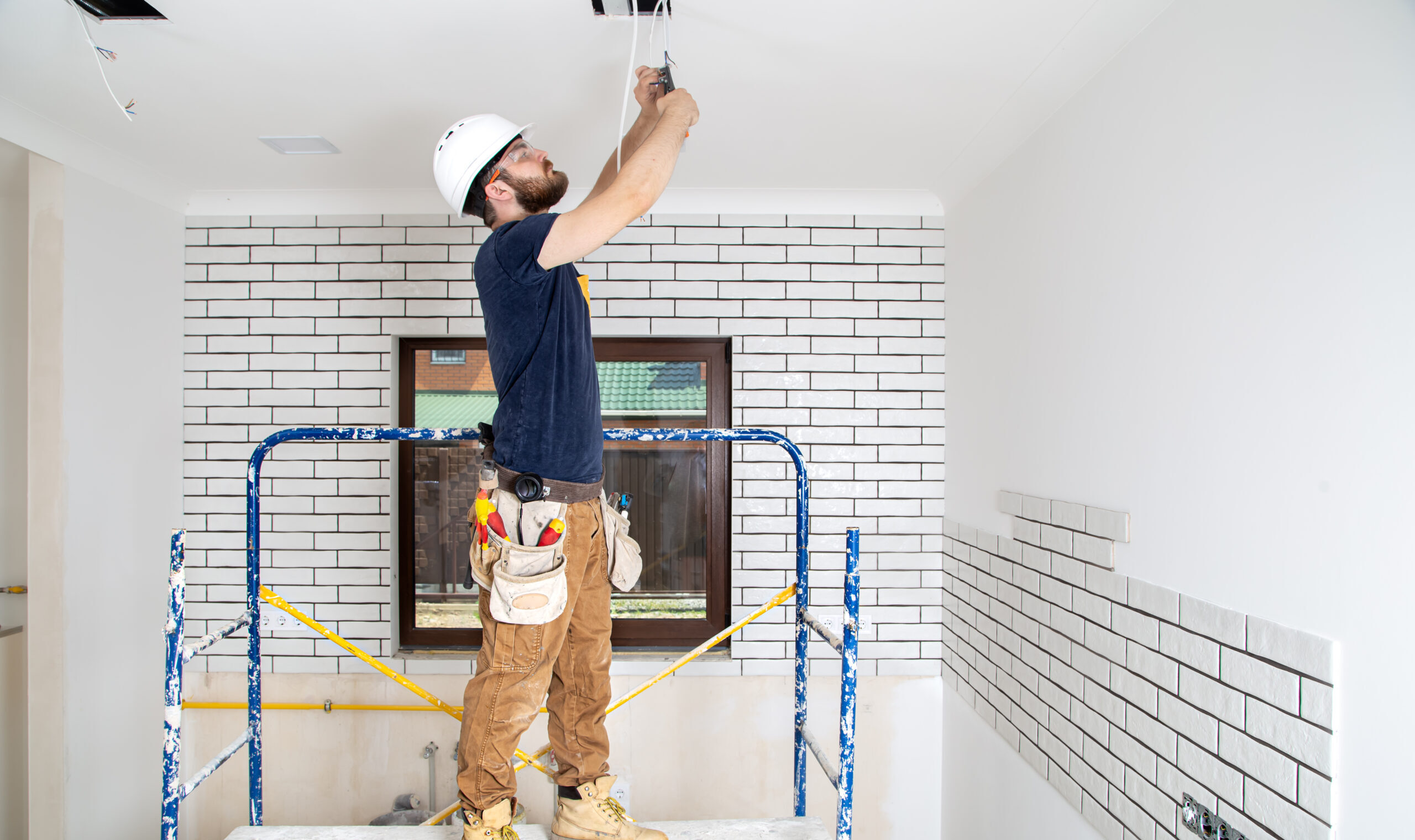 Professional in overalls with tools on the background of the repair site. Home renovation concept.